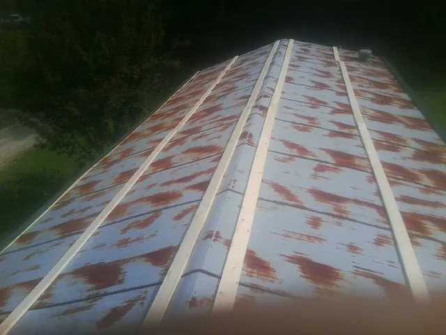 Rusted metal roof panels with new wood purlins before replacement — Storm Damage Roof Repair in Stone Mountain by Roofing Brothers