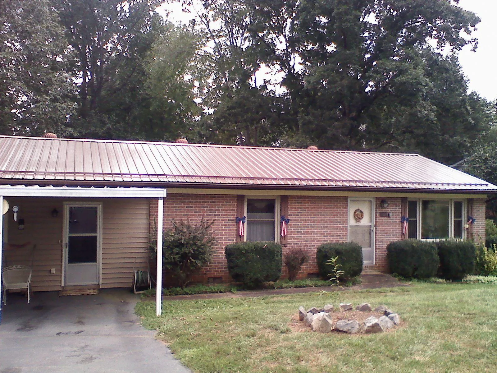 Bronze metal roof and carport on a brick ranch home — Roof Repair work by our crew in Stone Mountain