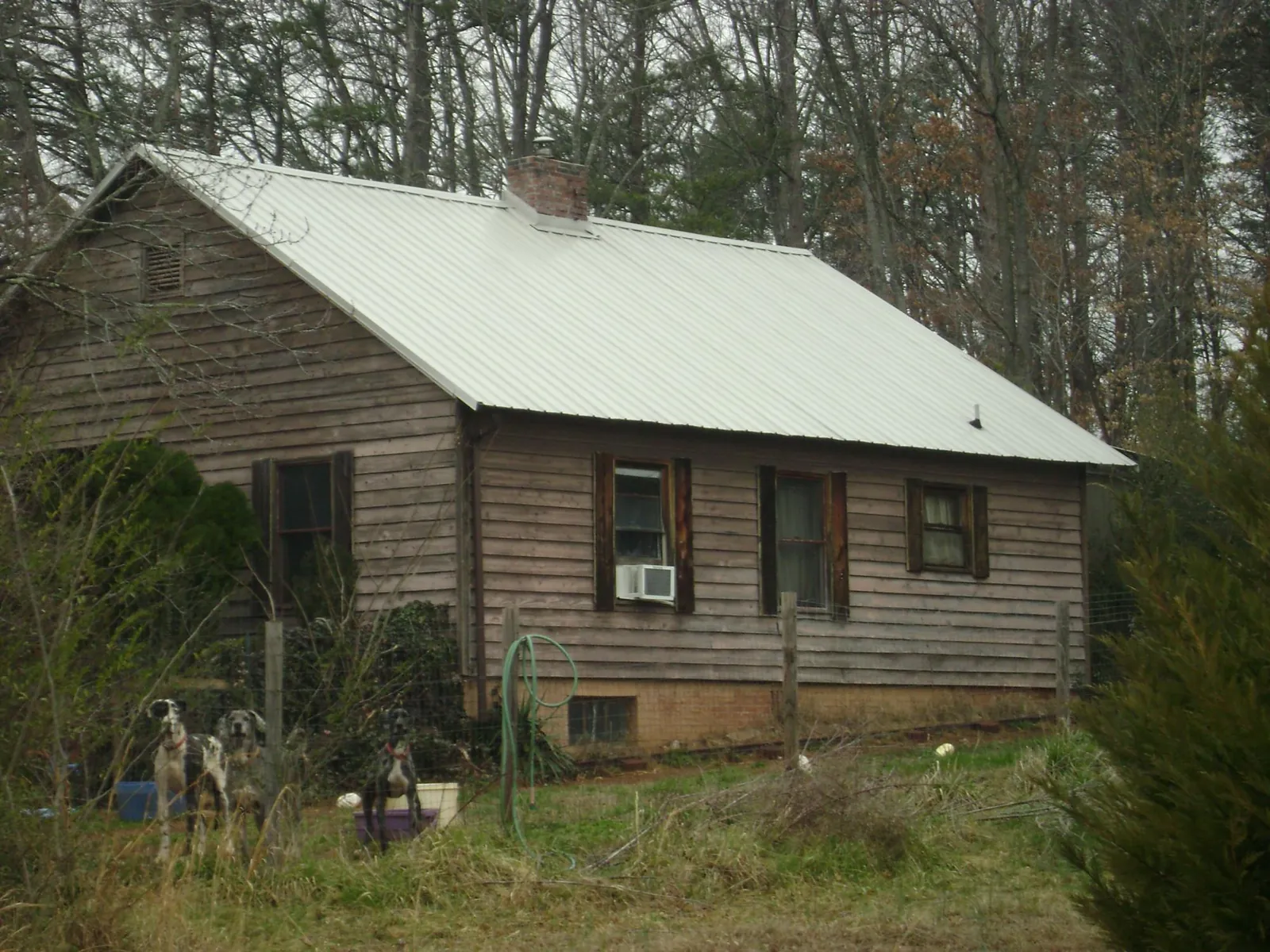 White metal roof on an old wood sided farmhouse, from a Metal Roof Installation job in Stone Mountain